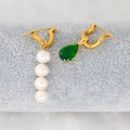 Detail of asymmetric gold earrings with white pearls and a pear-cut green zircon stone - Green