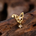 Macro view of gold butterfly cartilage stud with dangling cubic zirconia on wood - Hollow Butterfly Pendant Style (3141) / Gold