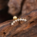 Macro shot of curved gold ear stud with seven inlaid zircons and ball back closure - Seven Zirconia Curved Row Style (3147) / Gold
