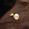 Macro detail of gold stud earring with two clear cubic zirconia on a dark wooden block - Yin Yang Disc Style (3445) / Gold