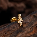 Piercing labret en forma de S bañado en oro con circonitas blancas sobre fondo de madera - Forma de Curva de Rayo de Onda (3361) / Dorado