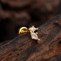 Minimalist gold plated ear stud with two marquise cut zircons on a dark wood background - Double Marquise Style (3385) / Gold