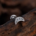 Silver crescent moon cartilage stud with white zircon on a natural wood surface - Crescent Style (3386) / Silver