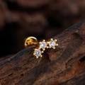 Gold plated ear stud with three curved zircons on a wooden background for piercings - Three-stone Arc Style (3388) / Gold