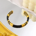 Detail view of C-shaped bamboo joint bangle in 18K gold plated steel and black enamel - Black