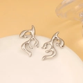 Macro detail of silver geometric flame stud earrings with liquid metal polished finish - Steel