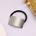 Close-up of rectangular brushed silver metal piece on a durable black elastic hair tie - Short Style / Silver