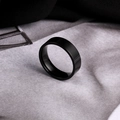 Close-up of matte and polished black stainless steel wide ring on textured surface - US 5 / Black
