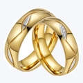 Detailed view of polished gold couple rings set with spiral grooves and zircon stones - Size 5 / With Zirconia
