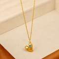 Dettaglio della collana a cuore dorata con gemme blu e rosse su vassoio in velluto - Collana Con Pendente a Cuore Con Zirconia Colorata (CK1382)