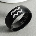 Macro shot of black titanium Aquarius ring featuring brushed finish and silver wave engraving - Aquarius