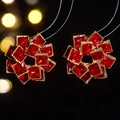 Close-up of flower earrings with red square-cut zircons and gold-tone base - Gold and Red Gorgeous Style