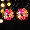 Macro detail of round flower cluster earrings with vibrant colorful square-cut gemstones - Gold and Multicolor Gemstone Style