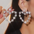 Dettaglio di grandi orecchini a cuore di lusso con fiori di cristallo su una modella - Orecchini a Cuore Grande a Grappolo di Fiori (BXE036S)