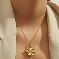 Elegant gold titanium steel flower pendant necklace shown on a model wearing a blazer - Five-petal Flower (DJN004GL)