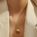 Golden shell pendant necklace in stainless steel on model with minimalist aesthetic - Scallop Shell (DJN003GL)