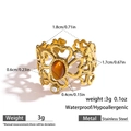 Macro shot of gold stainless steel ring featuring amber stone and clover cutout details - Amber