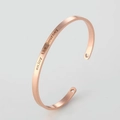 Detail of rose gold stainless steel cuff featuring enjoy the journey text and heart cutouts - 4mm / English Engraved Style / Rose Gold