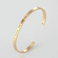 Detailed shot of gold cuff bracelet featuring enjoy the journey text and heart cutouts - 4mm / English Engraved Style / Gold