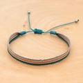 Macro shot of colorful bohemian woven bracelet on wood with adjustable silver beads - Teal Orange Green Striped Style (KZ-0031)