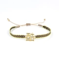 Détail d'un bracelet ethnique tressé avec un charm doré portant le caractère chinois Ku - Style Caractère Chinois Cool (KZ-Z0025)