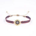 Détail d'un bracelet ethnique tissé main avec un motif œil turc en métal doré central - Œil Turc Rouge Bleu Blanc (KZ-Z0045)