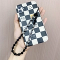 Detail van ruitjes telefoonhoesje met geluksbrengers en grijze kralen polsband accessoire - Cool Style Zwart Grijs Contrast Parel