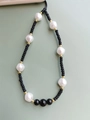 Detail of beaded phone strap with irregular pearls, matte black beads and golden spacers - Zz-a220001a