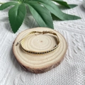 Detail van een bohemien handgemaakte gele gevlochten armband met blauwe patronen op hout - Geel Blauw Geweven Stijl (KZ-0071)