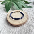 Bracelet tressé bohème bleu marine à motifs géométriques sur un socle en bois rustique - Style Triangle Géométrique Marine (KZ-0085)
