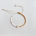 Detail van verstelbare kralenarmband met gouden accenten en schelphanger letter P - Letter P (BLS220006P)
