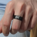 Primer plano de anillo de titanio negro con letra M grabada en la mano de un hombre - Talla 6 / Estilo Letra M (M566-M) / Negro