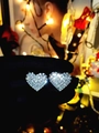 Dettaglio di orecchini a cuore argentati con strass scintillanti tenuti in mano - Cuore Pieno di Strass Argento (DTE1216159S)