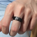 Primer plano de anillo de acero negro mate con grabado de letra N blanca en mano - Talla 6 / Estilo Letra N (M566-N) / Negro