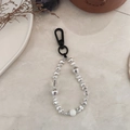 Dettaglio macro di perline di cristallo fatte a mano e ciondoli argentati sul portachiavi - Stile con Perline Irregolari Argento (YS-A230014B)