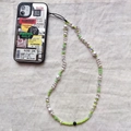 Detail van zilveren spiegel telefoonhoesje met vintage labels en kralen koord - Groen Kristal Kunstparel Telefoonketting (SJ-A210003B)