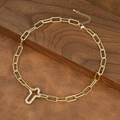 Macro shot of gold paperclip chain necklace with a sparkling rhinestone cross pendant - Cross Pendant Style (NE2599-F)