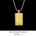 Macro shot of gold tarot necklace showing The Pope card with a white zircon accent - The Hierophant / Gold