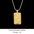 Macro detail of gold tarot card necklace featuring Strength VIII pendant with crystal - Strength / Gold