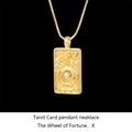Macro shot of gold Wheel of Fortune tarot pendant necklace with high relief detail - The Wheel of Fortune / Gold
