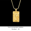 Macro detail of gold-plated The Devil tarot card pendant with a sparkling zircon inlay - Devil / Gold