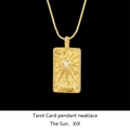 Macro shot of gold tarot sun pendant necklace with sparkling crystal inlay on black background - Sun / Gold