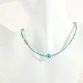 Detailed close-up of handmade glass eye beads with blue faceted stones and gold spacers - Apatite