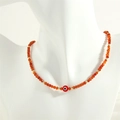 Detail of evil eye charm necklace with orange faceted beads on a mannequin bust - Red Agate