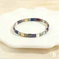 Close-up of Tila bead bracelet with purple and gold enamel tiles on a shell tray - Purple Gold Silver Mix (BR1688-B)