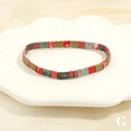 Detail shot of colorful Tila bead bracelet on a white ceramic leaf tray accessory - Red Green Gold Gray Rainbow Tila Mix (BR1688-G)