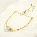 Detail eines verstellbaren 18K vergoldeten Perlenarmbandes mit hellblauem Naturstein - Aquamarin (BR1694)