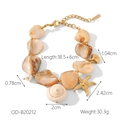 Dettaglio di un bracciale bohémien in oro e acciaio con conchiglie, perle e stelle marine - Bracciale con Conchiglia Grande (OD-B20212)