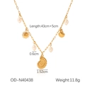 Dettaglio della collana dorata con conchiglie, catena a graffetta, perle e ciondoli - Collana con Nappina Oceano (OD-N40438)