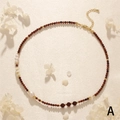 Detail einer Perlenkette mit rotem Achat, Süßwasserperlen und Goldverschluss auf Seide - Granat